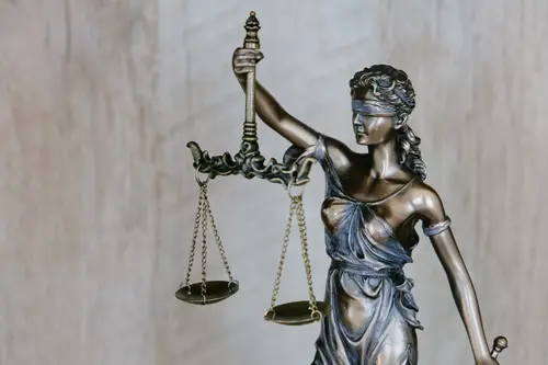 Nahaufnahme einer Bronzefigur der Justizia.